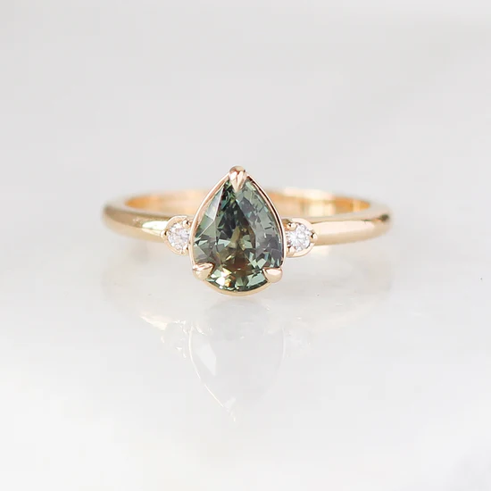 14k Yellow gold ring, Featuring a 1.40ct pear cut natural green sapphire, with
0.06ct round brilliant cut natural Canadian diamonds, GH/VS2