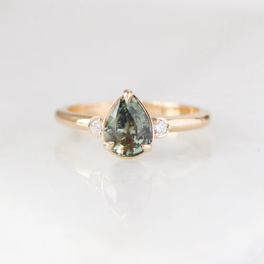 14k Yellow gold ring, Featuring a 1.40ct pear cut natural green sapphire, with
0.06ct round brilliant cut natural Canadian diamonds, GH/VS2