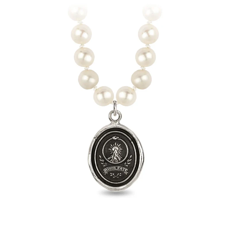 Ivory Freshwater Pearl Necklace with a Sterling Silver talisman depicting a Large mountain with a sun behind the peak, and the text "amor Fati" below it