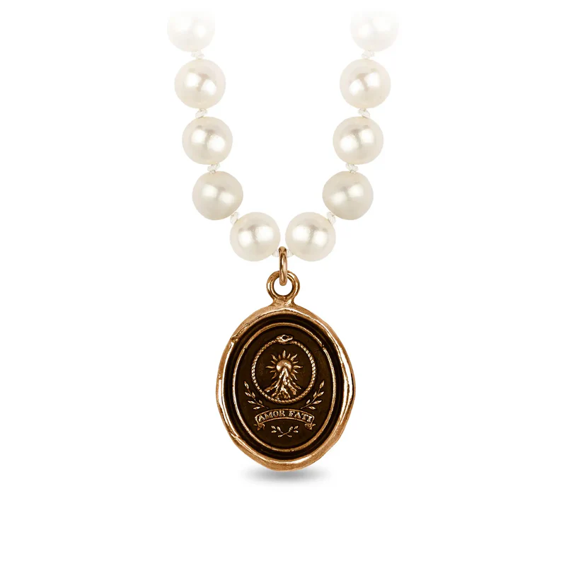 Ivory Freshwater Pearl Necklace with a Bronze talisman depicting a Large mountain with a sun behind the peak, and the text "amor Fati" below it