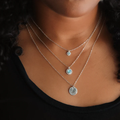 Sterling silver necklace featuring a ribbed circular pendant with a gemstone set at the center | on model
