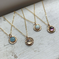 Sterling silver necklace featuring a ribbed circular pendant with a gemstone set at the center