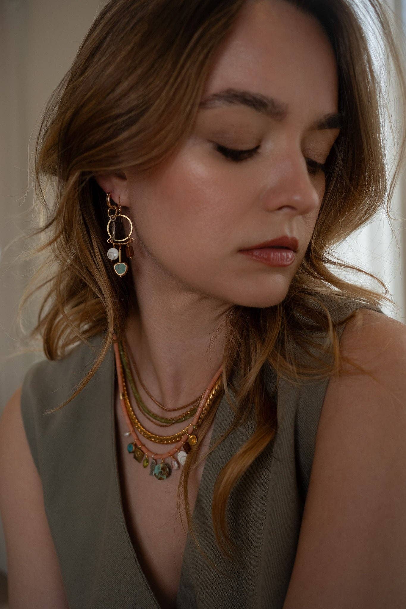 Baby Austra Earrings feature a unique combination of brass-edged Turquoise, Hessonite Shiva Shell | on model