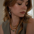 Baby Austra Earrings feature a unique combination of brass-edged Turquoise, Hessonite Shiva Shell | on model