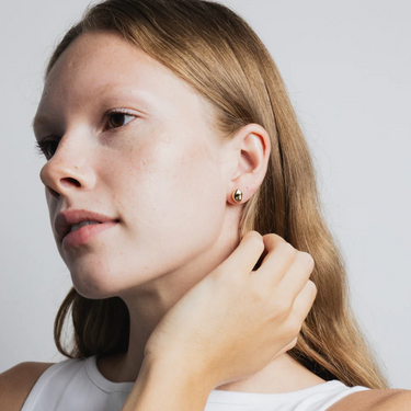 Small every day bean shaped stud earring made from 14k gold plated Brass | on model