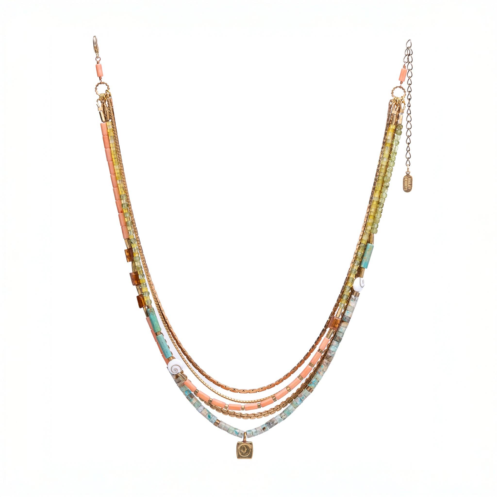 Belinay Necklace featuring a combination of shiva shell, dyed coral, hand-cut gemstones, and brass accents. With multiple strands and a variety of colours including Hessonite, Peridot, Yellow Jade, Turquoise, Dyed Coral, and Shiva Shell.