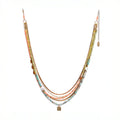 Belinay Necklace featuring a combination of shiva shell, dyed coral, hand-cut gemstones, and brass accents. With multiple strands and a variety of colours including Hessonite, Peridot, Yellow Jade, Turquoise, Dyed Coral, and Shiva Shell.