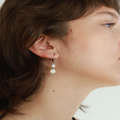 Delicate silver earrings with a freshwater pearl and a colorful bead | on model