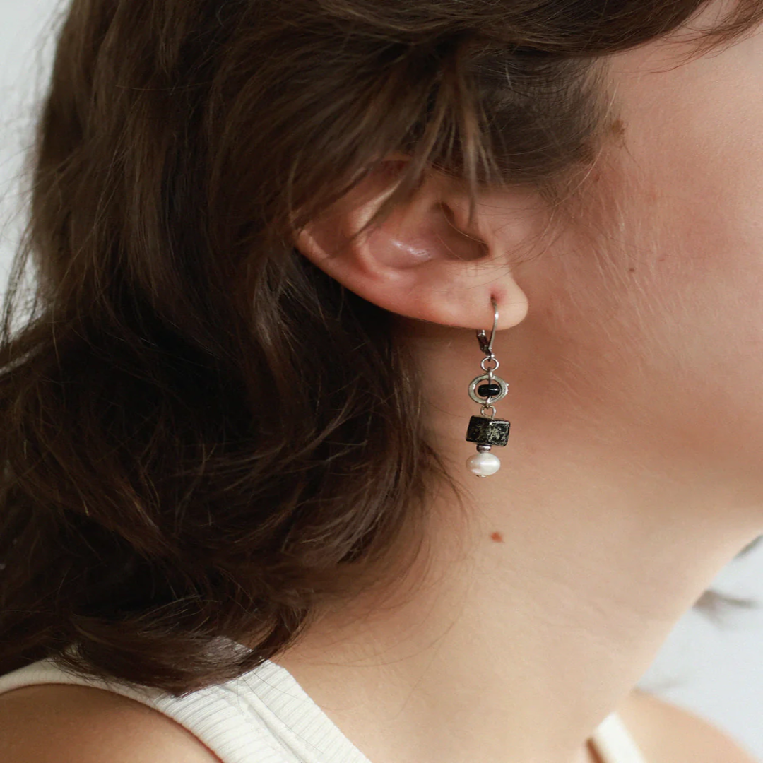 Short silver earrings featuring pewter accents, colorful glass beads, and a freshwater pearl | on model