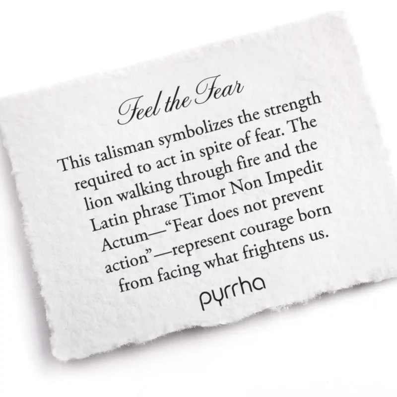 A Pyrrha note describing the Feel the Fear talisman. It reads, "This talisman symbolizes the strength required to act in spite of fear. The lion walking through fire and the Latin phrase Timor Non Impedit Actum—“Fear does not prevent action”—represent courage born from facing what frightens us."