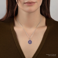 A Talisman necklace withe a violet colored background depicting a Lion standing with flames surrounding him, with the text "imor Non Impedit Actum", on the top and bottom of the talisman. | on model