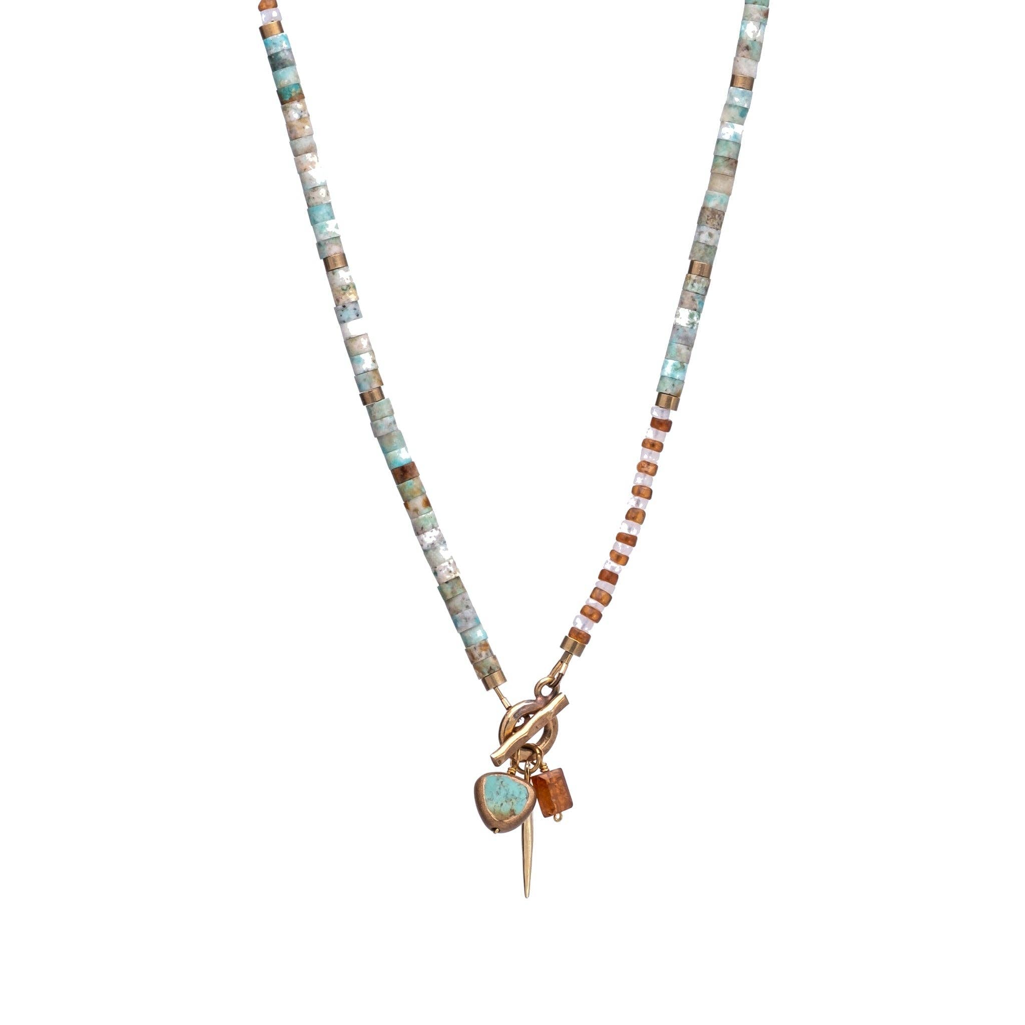 necklace featuring a striking combination of brass-edged Turquoise, Hessonite, and Moonstone beads, with a brass toggle clasp and a 14K gold-plated brass spike charm.