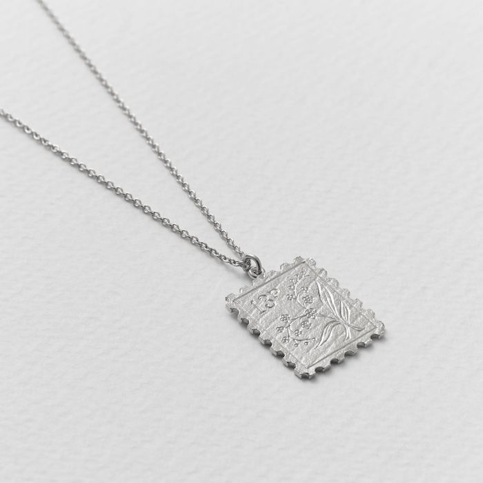 Silver Necklace with a stamp shaped pendant with a floral design