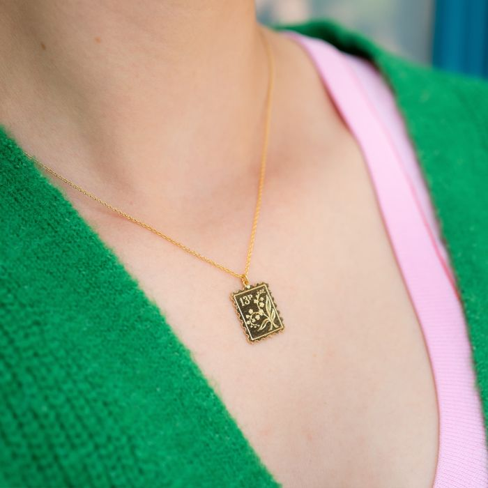 Silver Necklace with a stamp shaped pendant with a floral design | On Model