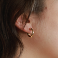 Organic-shaped matt gold hoop earrings | on model