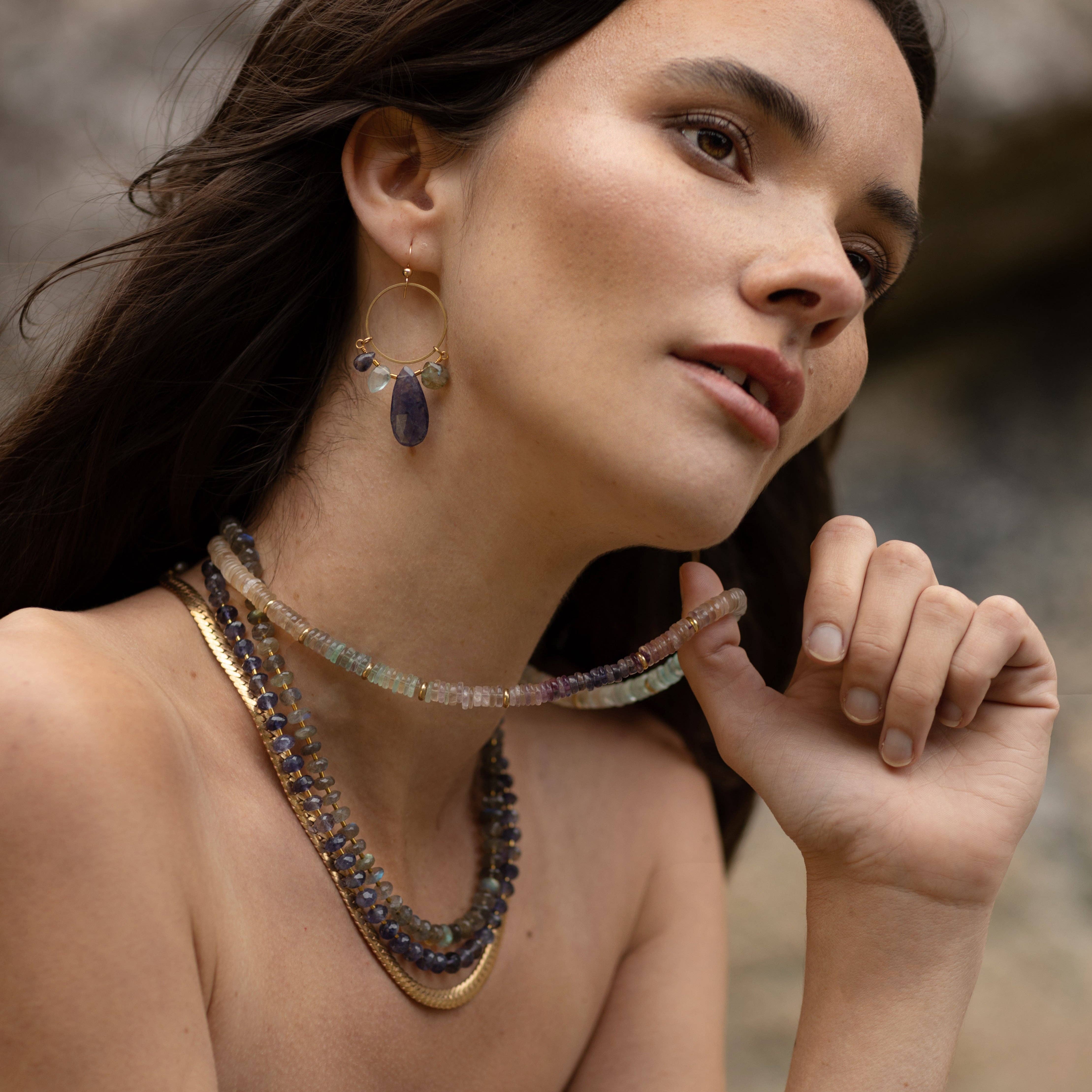 Glacial Ombre Necklace, featuring graduated colours of hand-cut Fluorite stones with Iolite accents and recycled brass beads asymmetrically spaced throughout. | on model