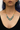 Plated Sterling Silver Necklace Featuring an Intricate Design with mixes of multicoloured Textile thread and multiple sizes of gemstones and beads. The main colours include tones of blue and green. | on model