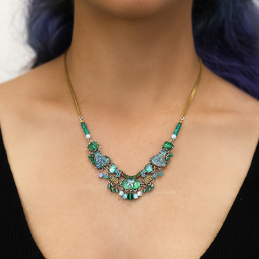 Plated Sterling Silver Necklace Featuring an Intricate Design with mixes of multicoloured Textile thread and multiple sizes of gemstones and beads. The main colours include tones of blue and green. | on model