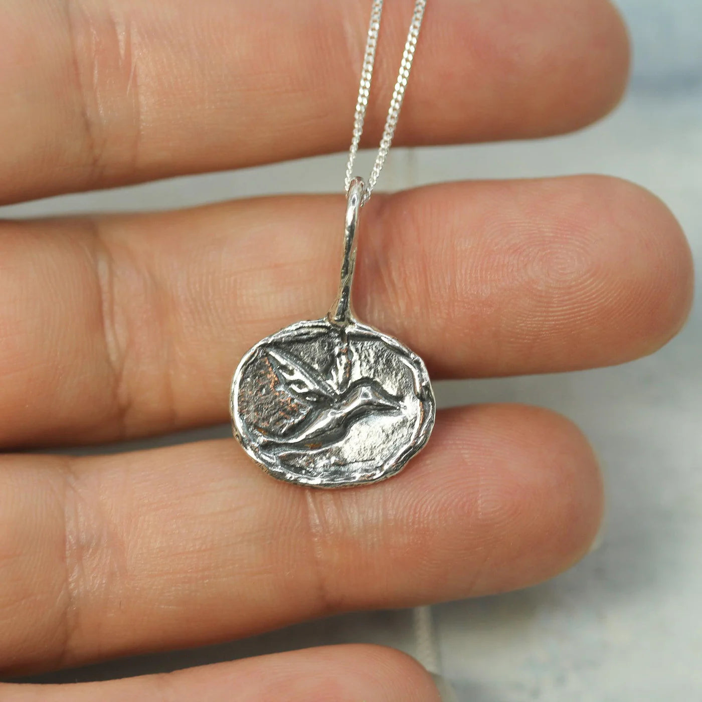 Humming bird hand carved into a sterling silver coin to make a beautiful pendant for this necklace.