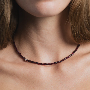 Small red garnet beaded necklace with a sterling silver lobster clasp | on model