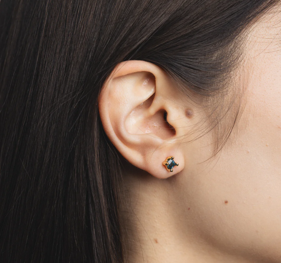 14k Gold plated brass studs with genuine blue topaz gemstones and gold vermeil posts | on model