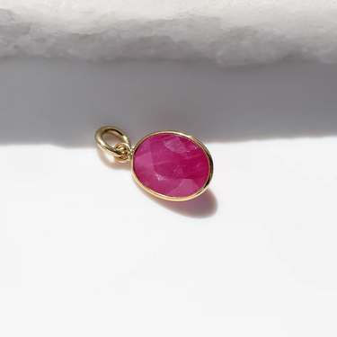 A colourful 14k Yellow Gold ruby charm that can be worn as a standalone pendant or added to a layered stack.