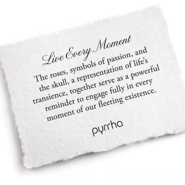 A Pyrrha note describing the Live Every Moment talisman. It reads, "The roses, symbols of passion, and the skull, a representation of life's transience, together serve as a powerful reminder to engage fully in every moment of our fleeting existence."