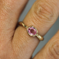 solid 14k yellow gold Ring featuring a .6ct oval pink sapphire | on model