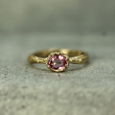 solid 14k yellow gold Ring featuring a .6ct oval pink sapphire