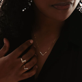 A mix of sterling silver and 14k yellow gold fill necklace splkit between a flat bar of gold, and beads of silver shaped to create a V | on model