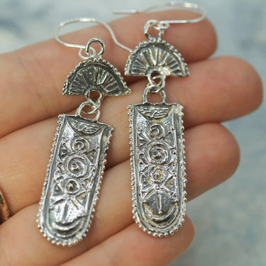 Design has imagery of the moon lighting up grassy hills and showing beautiful spiral symbols.