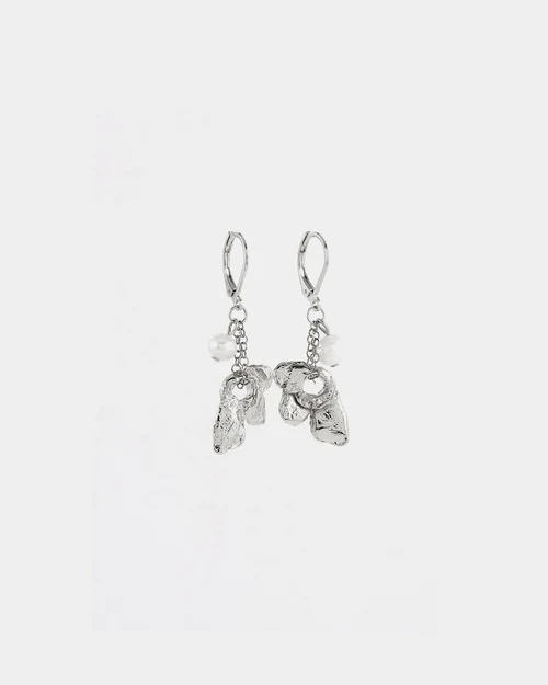 Short silver earrings adorned with a flower-shaped pewter pendant and a pearl