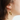 Short gold earrings adorned with a flower-shaped pewter pendant and a pearl | on model