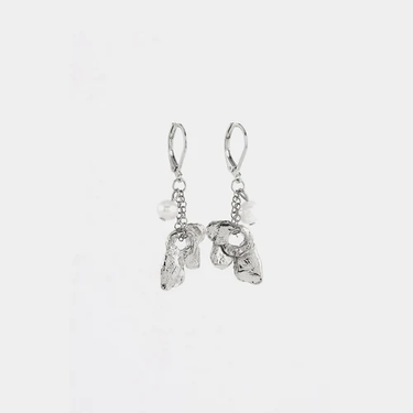 Short silver earrings adorned with a flower-shaped pewter pendant and a pearl