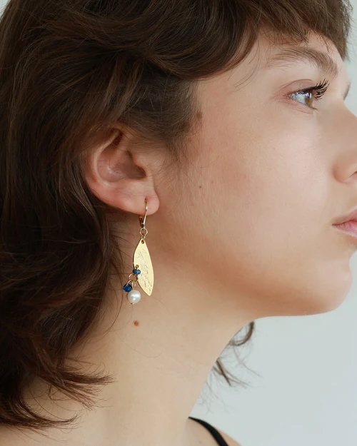 Short gold earrings with a winged pewter pendant and a cluster of colorful pearls | on model