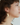 Short gold earrings with a winged pewter pendant and a cluster of colorful pearls | on model