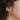 Silver pewter petal-shaped stud earrings with a freshwater pearl suspended behind the lobe | on model