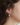 Silver pewter petal-shaped stud earrings with a freshwater pearl suspended behind the lobe | on model