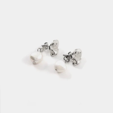 Silver pewter petal-shaped stud earrings with a freshwater pearl suspended behind the lobe