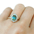 14k yellow gold ring, featuring an oval teal sapphire, 1.63ct | on model