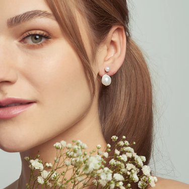 Pearl Earrings with A small round pearl combines with an organically shaped oval pearl | On model