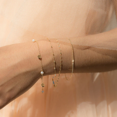 Gold Bracelet with Sweet baby pearls and light reflecting gold discs scatter evenly throughout a dainty 14k gold chain | on model