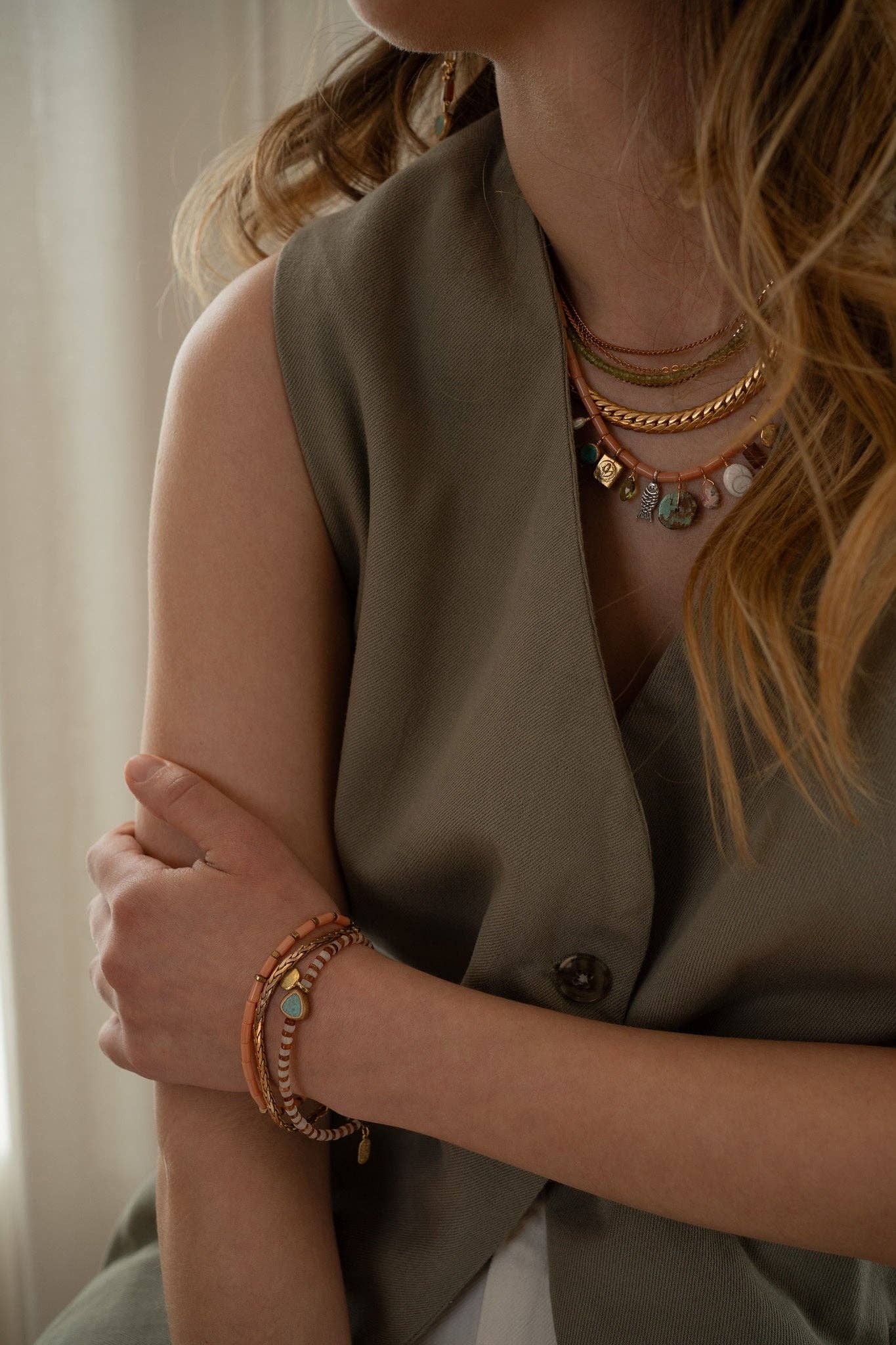 This unique bracelet features a combination of Hessonite, Moonstone, brass-edged Turquoise, and a 14K gold-plated brass coin pendant, all showcased in a striped pattern.  | on model