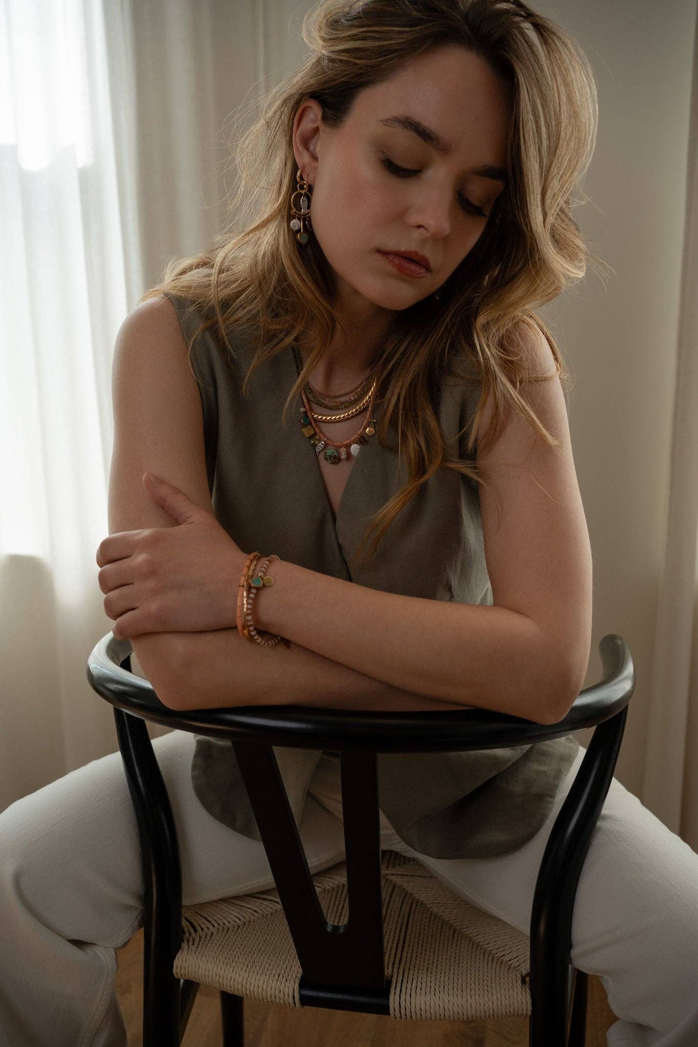 This unique bracelet features a combination of Hessonite, Moonstone, brass-edged Turquoise, and a 14K gold-plated brass coin pendant, all showcased in a striped pattern. | on model