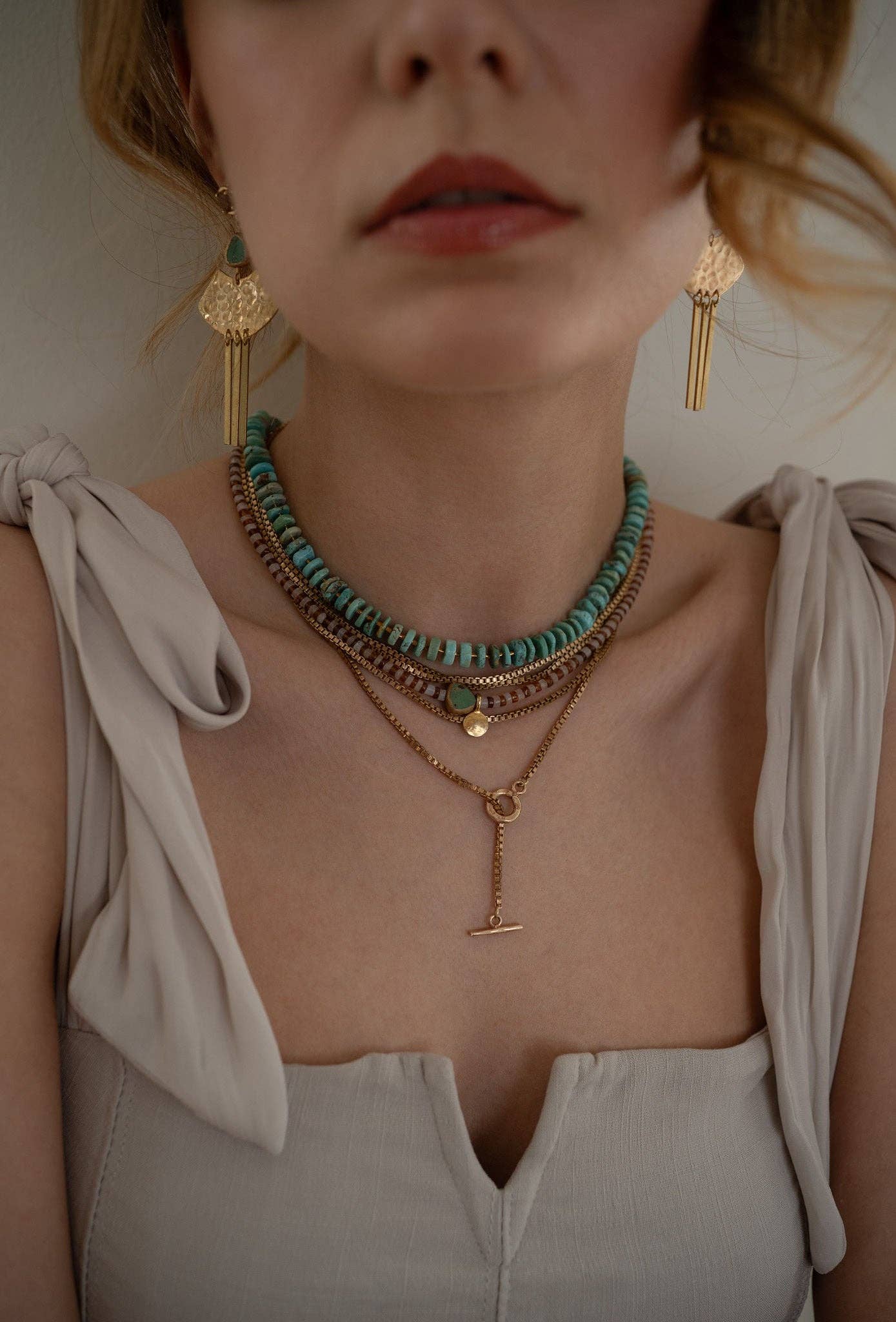  striped necklace showcasing Hessonite, Moonstone, brass-edged Turquoise triangle and 14K gold-plated brass coin pendant.  | on model