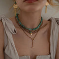  striped necklace showcasing Hessonite, Moonstone, brass-edged Turquoise triangle and 14K gold-plated brass coin pendant.  | on model