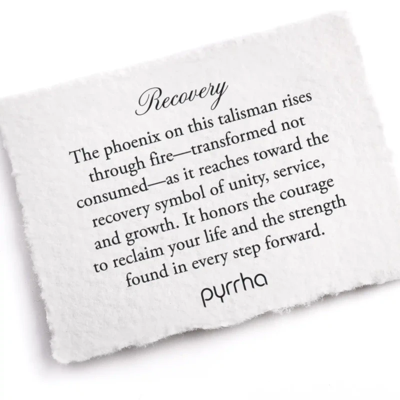A Pyrrha note describing the Recovery talisman. It reads, "The phoenix on this talisman rises through fire—transformed not consumed—as it reaches toward the recovery symbol of unity, service, and growth. It honors the courage to reclaim your life and the strength found in every step forward."