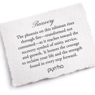 A Pyrrha note describing the Recovery talisman. It reads, "The phoenix on this talisman rises through fire— transformed not consumed—as it reaches toward the recovery symbol of unity, service, and growth. It honors the courage to reclaim your life and the strength found in every step forward."