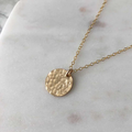 14k yellow gold fill necklace featuring a medallion pendant with a hammered texture 