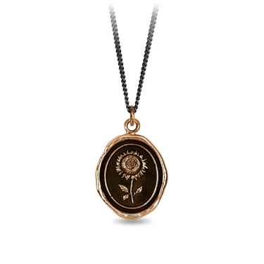 A Bronze Pyrrha Talisman With a black background depicting a Large Upright Sunflower